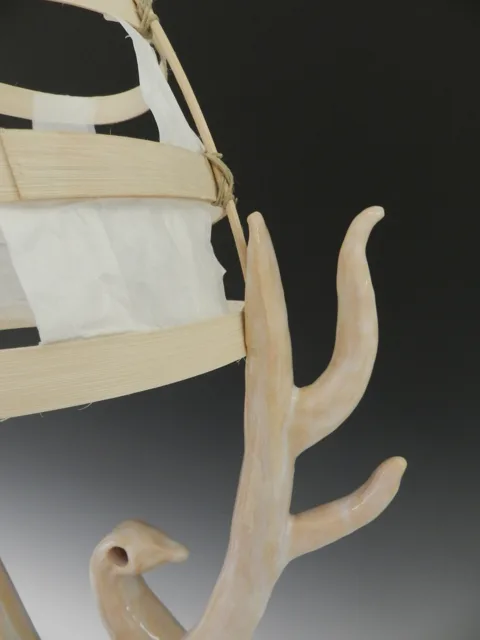 Detail of a curved pale sculptural support and suspended panel.