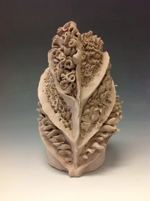 A textured leaf-shaped sculpture with a central seam.