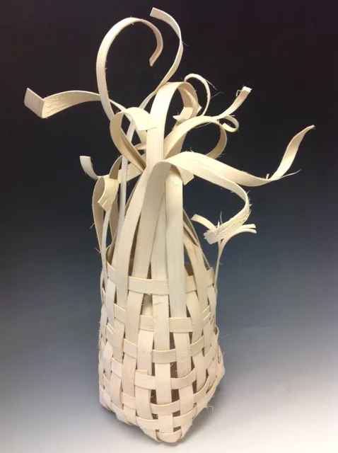 A pale woven vessel with curled strips extending from its opening.