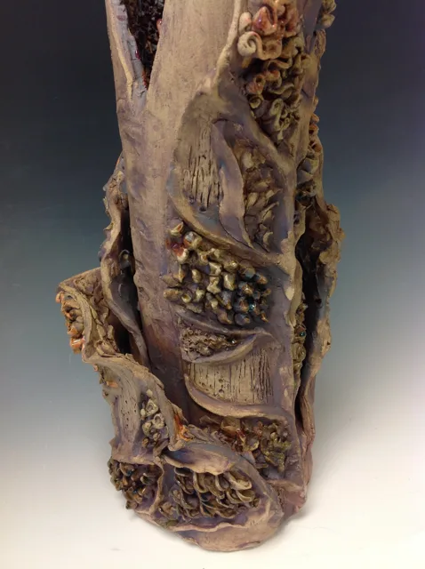 A tall organic sculpture with branching tips and a textured base.