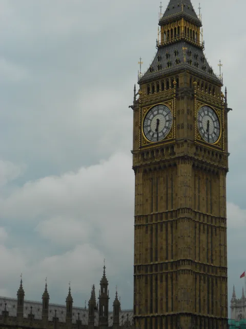 The clock tower rising above the street, viewed from below.