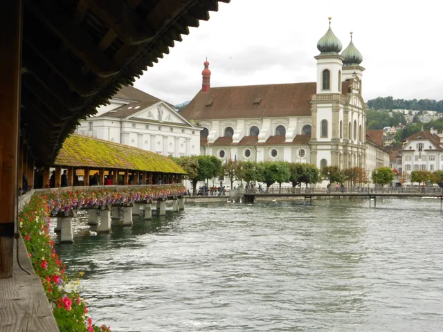 Riverside buildings framed by the roof of a covered bridge.