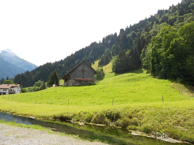 A mountain village surrounded by bright green slopes.