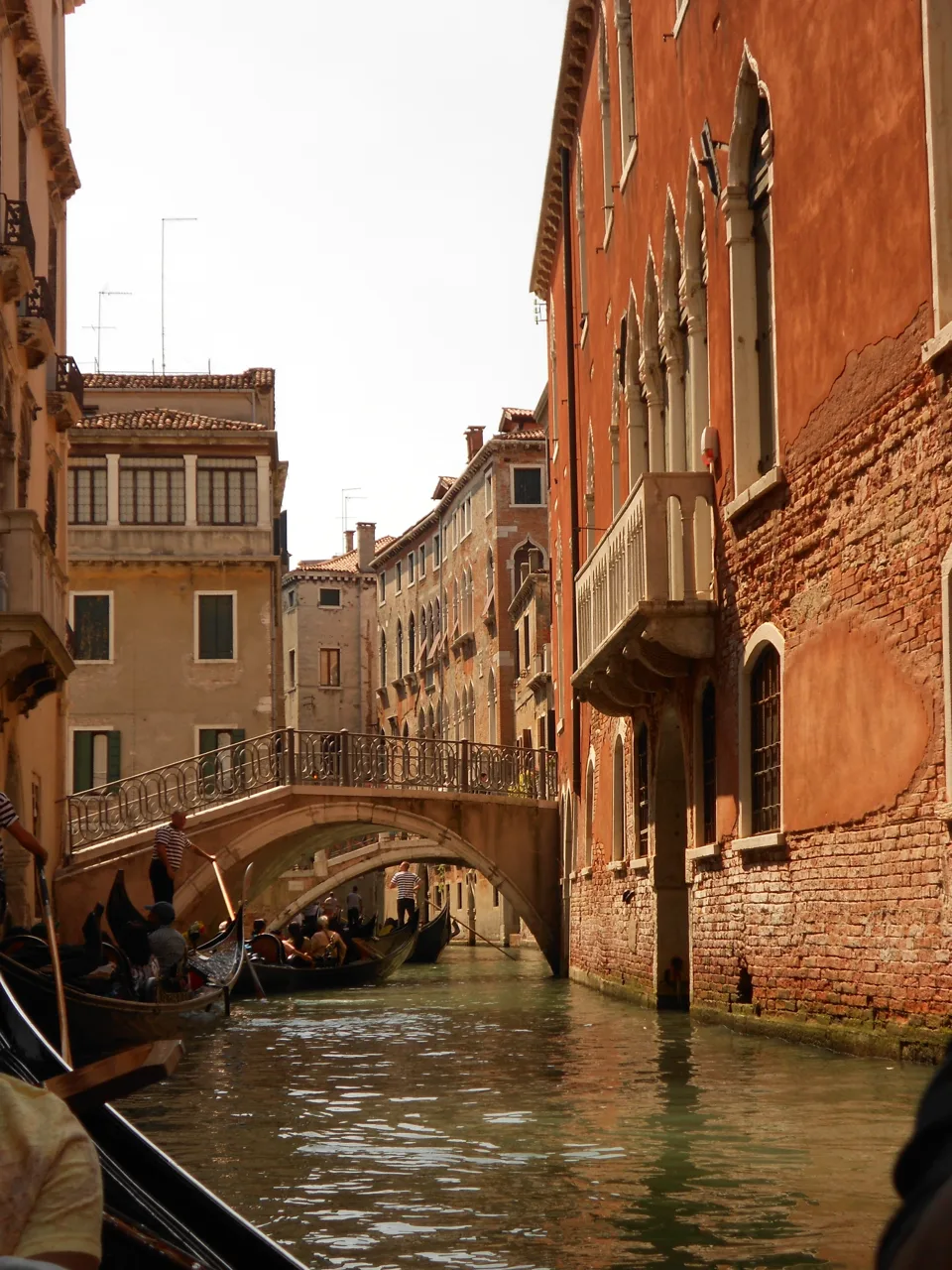 Boats on a canal bordered by warm-colored buildings.