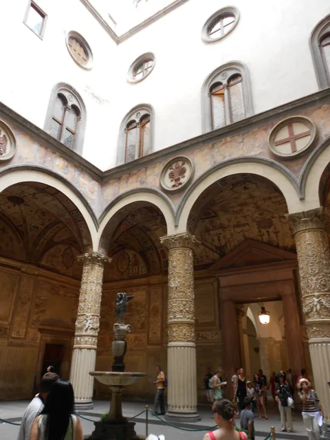 An arcaded courtyard with patterned stone walls.