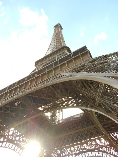 The curved iron structure of a tower viewed from below.