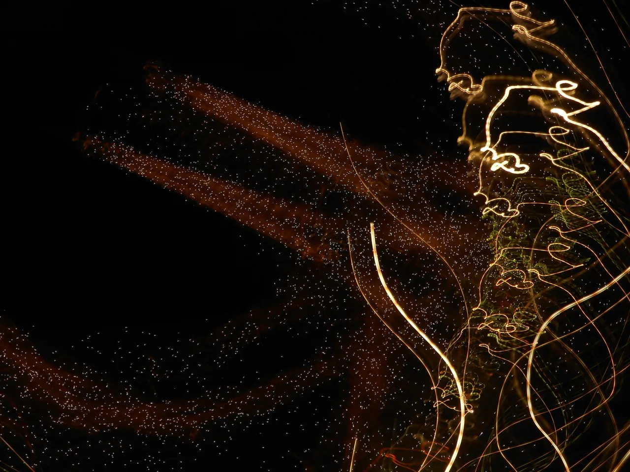 Golden light trails forming a loose figure against a dark background.