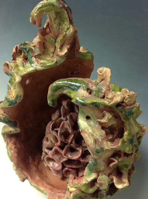 An open organic vessel containing curled branching forms.