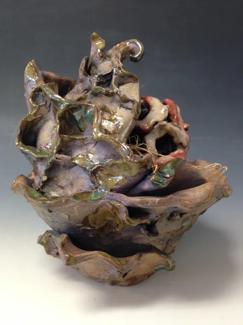A low irregular sculpture with curled branches and small rounded forms.