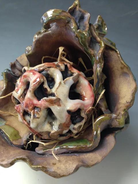 A rounded open sculpture with pale curling tendrils.