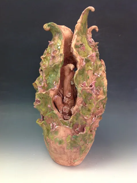 A slender upright sculpture with an open pink interior.