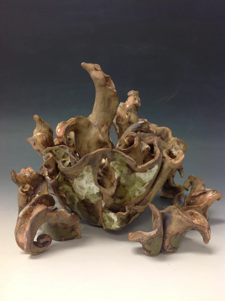 A low sculptural form with layered folds and rounded protrusions.