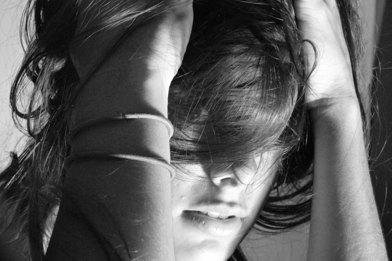 Black-and-white portrait with striped light across the forehead and hair.