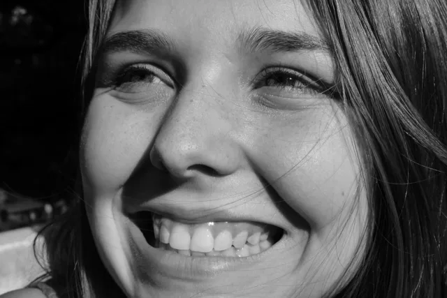 Black-and-white close-up of a smiling face.