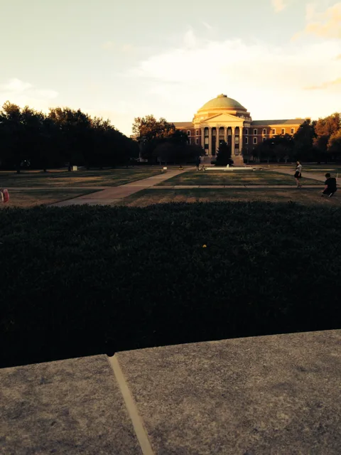 A domed building and garden under a softly glowing sky.