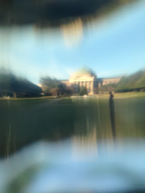 A domed building refracted through a curved transparent surface.