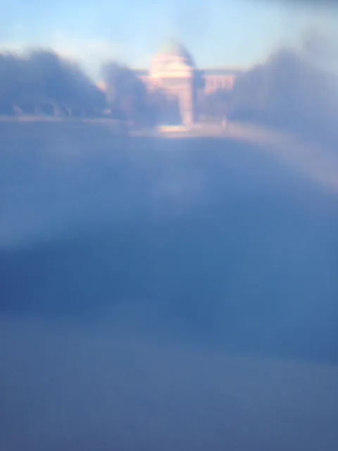 A softly distorted dome behind a translucent blue foreground.
