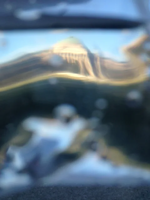 A fragmented view of a dome through rippled transparent material.