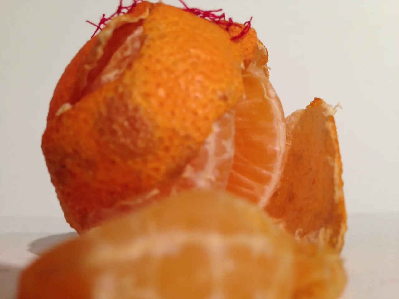 Detail of a peeled orange repaired with colored thread.