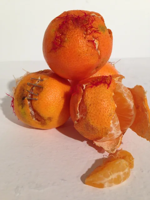 Stacked oranges with exposed segments and stitched seams.
