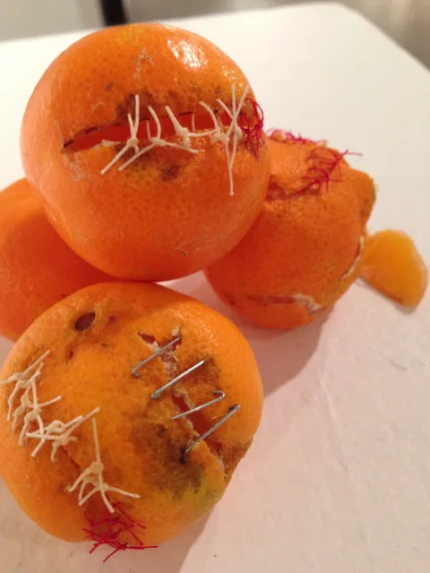 Close detail of a pile of oranges with contrasting stitched seams.