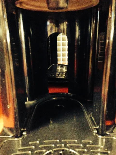 Close view of a drink dispenser framed by warm reflections.