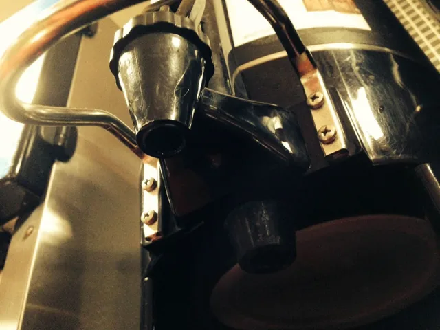 Metal coffee pots and handles clustered on a counter.
