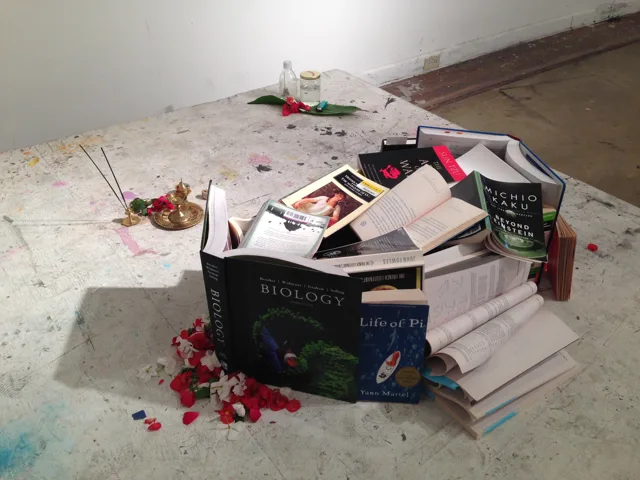A circular grouping of books and objects on a stone floor.