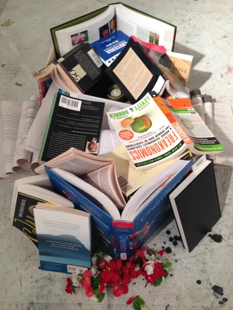 A close overhead view of layered books and photographs.
